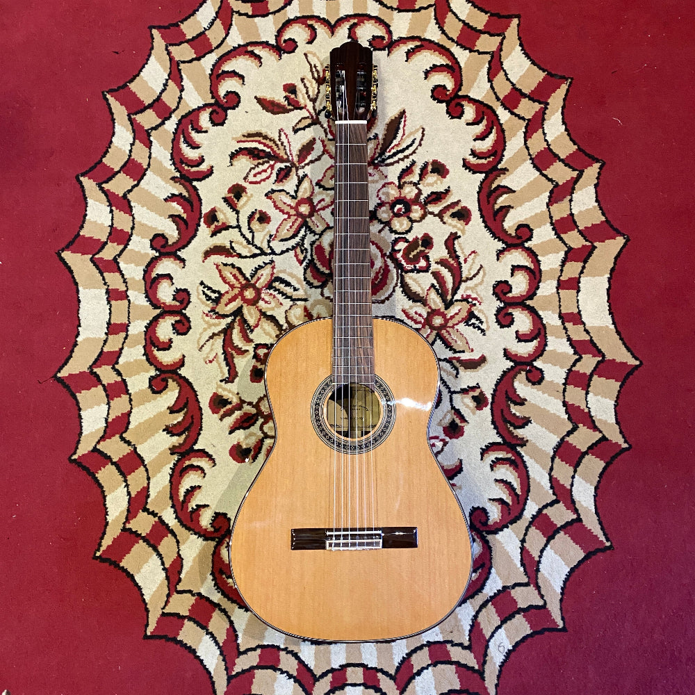 Acoustic guitar on a decorative red and beige rug