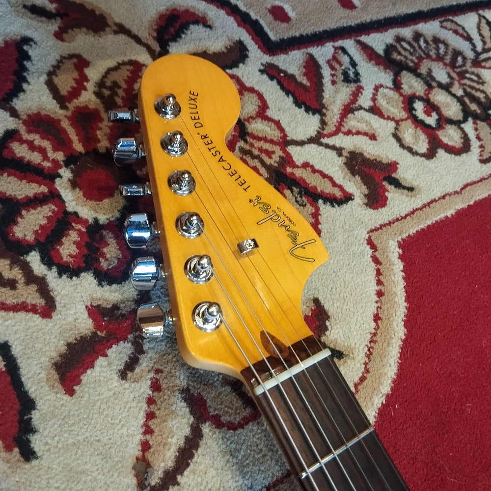 Front view of the headstock of a Fender American Pro II Telecaster Deluxe electric guitar, showing the Fender logo and tuning pegs.
