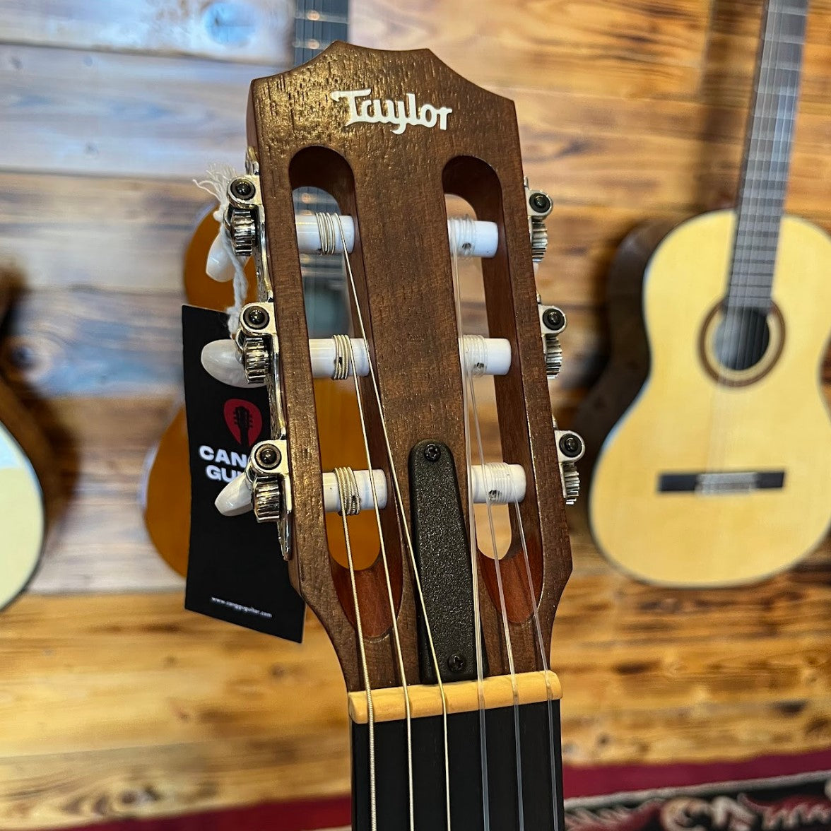 Headstock of a Taylor Academy 12e Nylon acoustic guitar with slotted design
