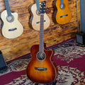 Acoustic guitar with a solid spruce top, acacia back and sides, and rosewood fingerboard. The guitar is displayed on a patterned red and beige rug without a case.