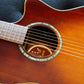 Model tag of an acoustic guitar, visible through the sound hole, displaying the brand name and model number.