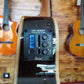 Side body of a TOM ukulele showing the UK500T chromatic tuner preamp system with control buttons and display screen.
