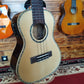 Front body of a TOM ukulele, showing the sound hole, bridge, and smooth wood finish.