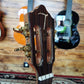 Front headstock of a TOM ukulele, featuring the TOM logo and tuning pegs.