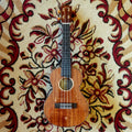 An electric ukulele with a solid acacia body and rosewood fingerboard, placed on a floral-patterned carpet.