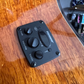 Close-up of the preamp on an acoustic guitar with natural wood color, showing the control panel on the side.