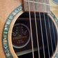 Model tag of an acoustic guitar, visible through the sound hole, displaying the brand name and model number.