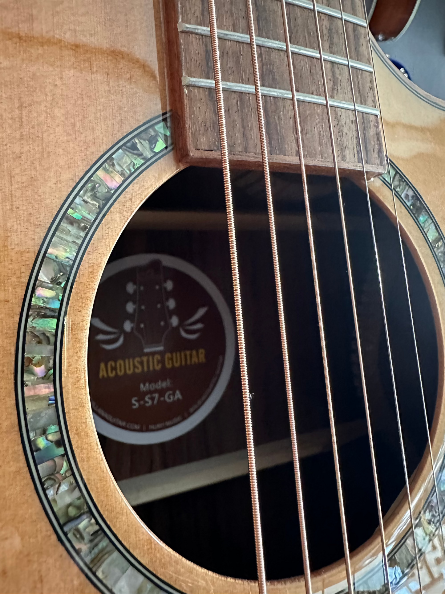 Model tag of an acoustic guitar, visible through the sound hole, displaying the brand name and model number.