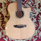 Acoustic guitar with a solid spruce top, acacia back and sides, and rosewood fingerboard. The guitar is displayed on a patterned red and beige rug without a case.