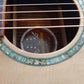 Model tag of an acoustic guitar, visible through the sound hole, displaying the brand name and model number.