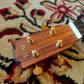 Headstock of a ukulele with tuning pegs and a visible brand logo